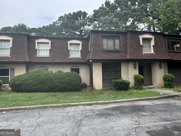 Modest townhouse with brown shingles and manicured shrubbery at 2968 Par Lorraine, Lithonia, GA 30038