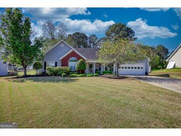 Well-maintained single story home with beautiful yard and attached two car garage at 50 Berkshire Pass, Covington, GA 30016