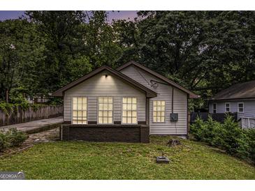 Charming bungalow featuring a well-manicured lawn and three windows that enhance the facade at 523 Mount Zion, Hapeville, GA 30354