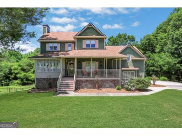 Inviting two-story home with a charming front porch and well-manicured lawn at 940 Planters Pl, Loganville, GA 30052
