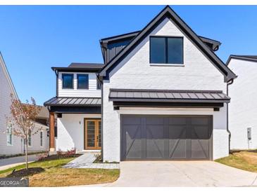 Striking modern home featuring a white brick facade, black trim, and attached garage at 1240 Hayes Sq, Peachtree City, GA 30269