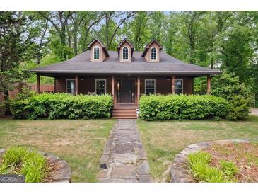 Charming home featuring a cozy front porch, dormer windows, and a well-maintained lawn at 68 Edwin Pl, Atlanta, GA 30318