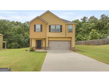 Inviting two-story home with a neutral color scheme, a two-car garage, and a well-manicured lawn at 340 Mcgiboney Ln, Covington, GA 30016