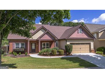 Charming single-story home with manicured lawn, brick accents, and attached two-car garage at 474 Strawberry Walk, Loganville, GA 30052