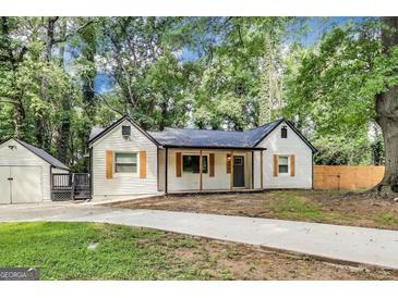 Charming home features a welcoming front porch, dark roof, detached garage, and spacious driveway at 500 Pomona Circle Sw, Atlanta, GA 30315