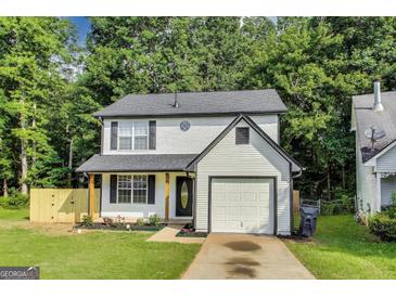 Charming two-story home features a classic white exterior, black shutters, and an attached one-car garage at 131 Turning Pt, Stockbridge, GA 30281