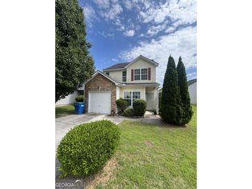 Charming two-story home with stone accents, a well-maintained lawn, and mature trees at 2208 Crossrail Dr, Atlanta, GA 30349