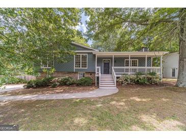 Charming home with a covered front porch, well-maintained landscaping and mature trees at 3404 Broxton Mill Way, Snellville, GA 30039