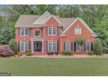 Charming two-story red brick home with black shutters and manicured lawn at 165 Hidden Lake Dr, Fayetteville, GA 30215