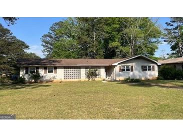 Charming single-story home with a well-maintained lawn and decorative lattice feature at 503 Roy Huie Rd, Riverdale, GA 30274