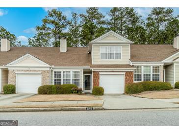 Inviting townhouse with a manicured lawn, attached garage, and partial brick facade at 124 Camry Sw Ln, Grayson, GA 30017