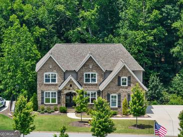 Stunning two-story brick home featuring a meticulously landscaped front yard, a welcoming entrance, and charming black shutters at 3525 Montebello Pkwy, Cumming, GA 30028