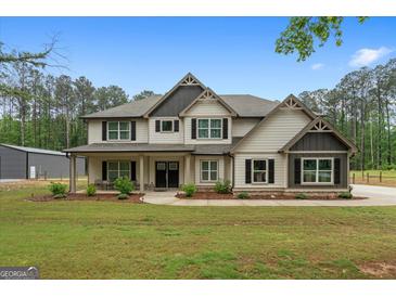 Charming two-story home with a well-manicured lawn, covered porch, and black-trimmed windows at 337 Paynes Lake Rd, Carrollton, GA 30116