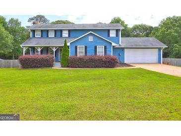 Charming two-story blue home featuring a well-manicured lawn and a two-car garage at 108 Country Acres Ct, Mcdonough, GA 30253