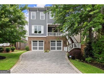 Beautiful two-story home with brick and grey siding, featuring a paver driveway and two-car garage at 1104 Victoria Ne St, Atlanta, GA 30319