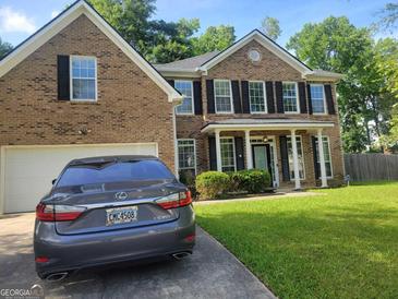 Beautiful two-story brick home with a well-manicured lawn and mature trees providing shade at 692 Sedgwick Dr, Jonesboro, GA 30238