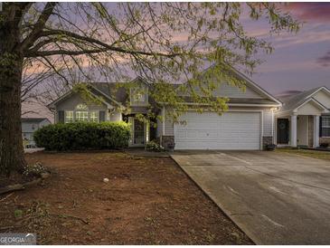Charming single-Gathering home with a two-car garage and mature tree in the front yard at 1765 Neighborhood Walk, Mcdonough, GA 30252