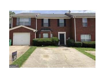 Traditional brick townhome with front yard and attached one car garage at 5658 Wind Gate Ln, Lithonia, GA 30058