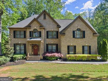 Charming two-story brick home with manicured lawn, inviting entrance, and professionally landscaped yard at 4680 Brighton Lake Dr, Cumming, GA 30040