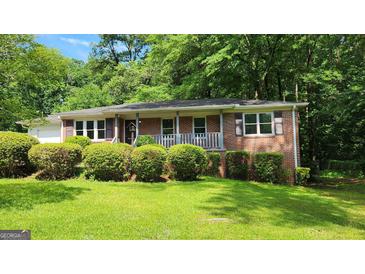 Charming brick home with a well-manicured lawn and mature trees offers great curb appeal at 766 Virginia Cir, Forest Park, GA 30297