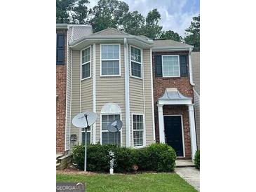 Two-story townhome with brick and vinyl siding, tidy landscaping, and inviting front porch at 8170 Oakley Cir # 2, Union City, GA 30291