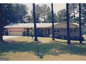 Charming ranch-style home with a brick facade, a two-car garage, and a well-maintained front lawn at 5125 Flakes Mill Rd, Ellenwood, GA 30294