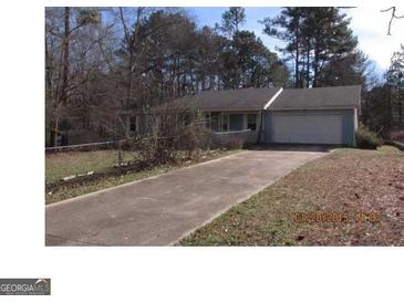 Charming single-story home featuring a long driveway and an attached garage, nestled amongst mature trees in a quiet neighborhood at 790 Mount Zion Nw Rd, Conyers, GA 30012