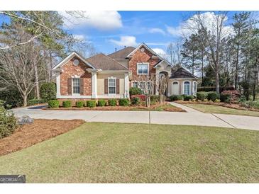 Beautiful brick home with a well-manicured lawn and inviting circular driveway at 612 Champions Dr, Mcdonough, GA 30253