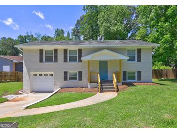 Charming two-story brick home with a well-manicured lawn and inviting front entrance at 1026 Ponderosa Park Dr, Forest Park, GA 30297
