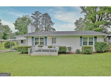 Charming single-story home with a well-manicured lawn and welcoming front porch with flower planters at 270 E James Cir, Hampton, GA 30228