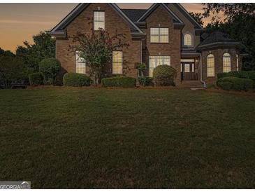 Charming brick home with manicured lawn and mature landscaping at 1500 Royce Dr, Locust Grove, GA 30248