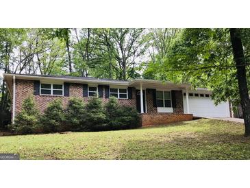 Charming brick home with black shutters, a well-manicured lawn, and mature trees at 5724 Amalfi Way, Douglasville, GA 30135