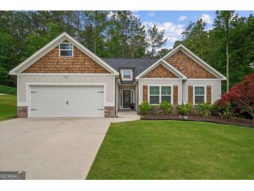 Charming single-Gathering home with a well-manicured lawn, garage, and beautiful wood and stone accents at 9178 Lakeview Pkwy, Villa Rica, GA 30180