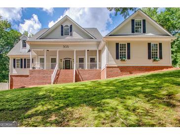 Charming two-story traditional home featuring a welcoming front porch and brick accents at 305 Postwood Dr, Fayetteville, GA 30215