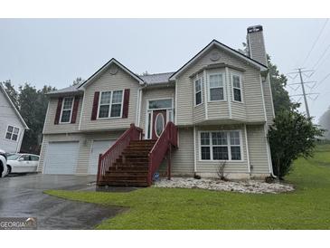 Charming two-story home featuring a well-maintained lawn, attached garage, and classic siding at 650 Flippen Rd, Stockbridge, GA 30281