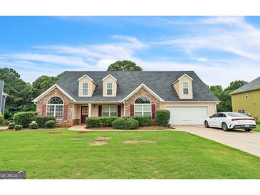 Charming single-Gathering home with stone accents, manicured lawn, dormer windows, and attached garage in a suburban neighborhood at 115 Glen Echo Dr., Covington, GA 30016