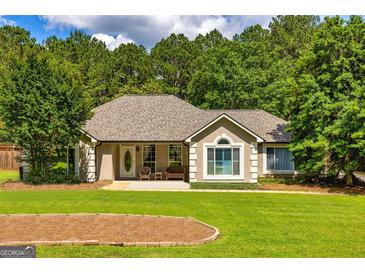 Charming home featuring a well-manicured lawn and a welcoming entrance with seating at 130 Laurel Lake Rd, Tyrone, GA 30290