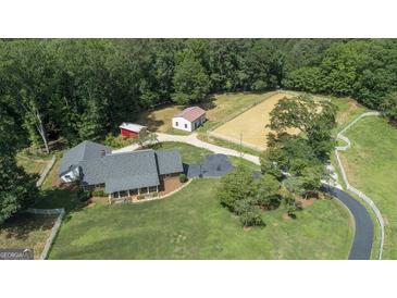 Expansive property featuring a large house, horse arena, and outbuildings surrounded by lush greenery at 135 Brookshire Dr, Fayetteville, GA 30215