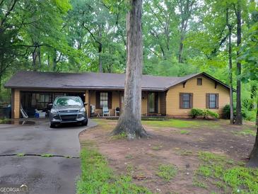 Charming single-story home featuring a long driveway, an attached garage, and a well-shaded front yard at 106 Garden Trl, Stockbridge, GA 30281
