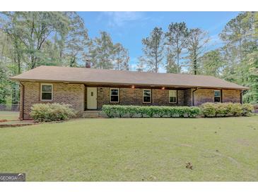 Charming one-story brick home with manicured lawn and lush surrounding greenery at 9706 Holly Hill Way, Jonesboro, GA 30238