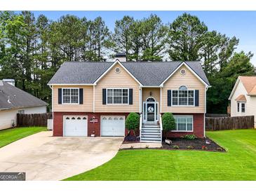 Charming home featuring a brick and siding exterior, well-manicured lawn, and an inviting front entrance at 341 Jodeco Station E Cir, Stockbridge, GA 30281