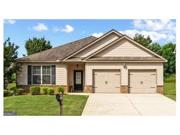 Charming single-story home with a well-manicured lawn and attached two-car garage at 697 Emporia Loop, Mcdonough, GA 30253