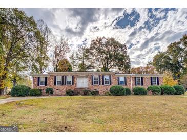 Charming one-story brick home featuring classic shutters, a well-maintained lawn, and inviting curb appeal at 7111 Indian Creek Sw Cir, Covington, GA 30014