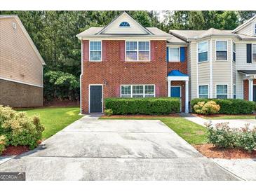 Charming red brick townhouse featuring a well-maintained front yard and a private driveway at 4862 Park Cir, Atlanta, GA 30349