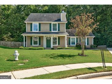 Charming two-story home featuring a well-manicured lawn and classic green shutters at 1600 Coal Shovel Ne Trl, Conyers, GA 30013