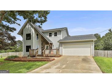 Charming two-story home featuring a stone accent wall, attached two-car garage, and inviting front porch at 125 Drennan Dr, Fayetteville, GA 30215
