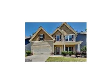 Charming two-story home featuring a welcoming front porch, attached garage, and manicured lawn at 473 Cherry Creek Dr, Loganville, GA 30052