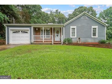 Charming single-story home with a cozy, brick-accented front porch, and a well-maintained front yard at 295 Pinehurst Dr, Stockbridge, GA 30281