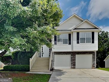 Charming home featuring a two-car garage and a welcoming front porch with stairs at 426 Summer Hill Cir, Stockbridge, GA 30281