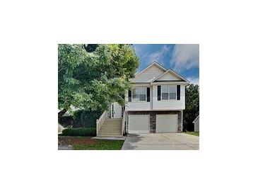 Inviting two-story home featuring a two-car garage and a charming stairway leading to the front door at 426 Summer Hill Cir, Stockbridge, GA 30281